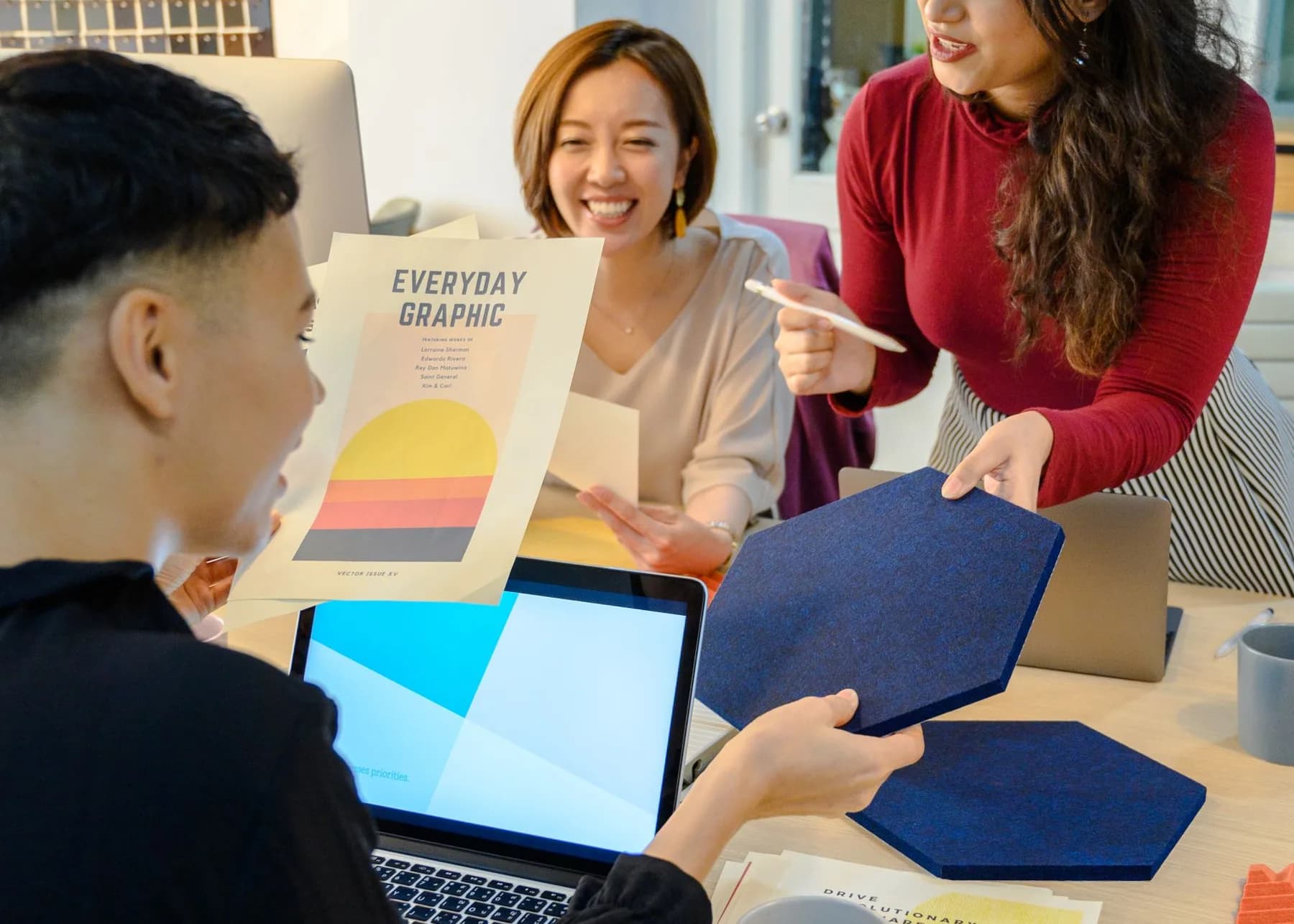 A creative team reviewing graphic design concepts and material samples
