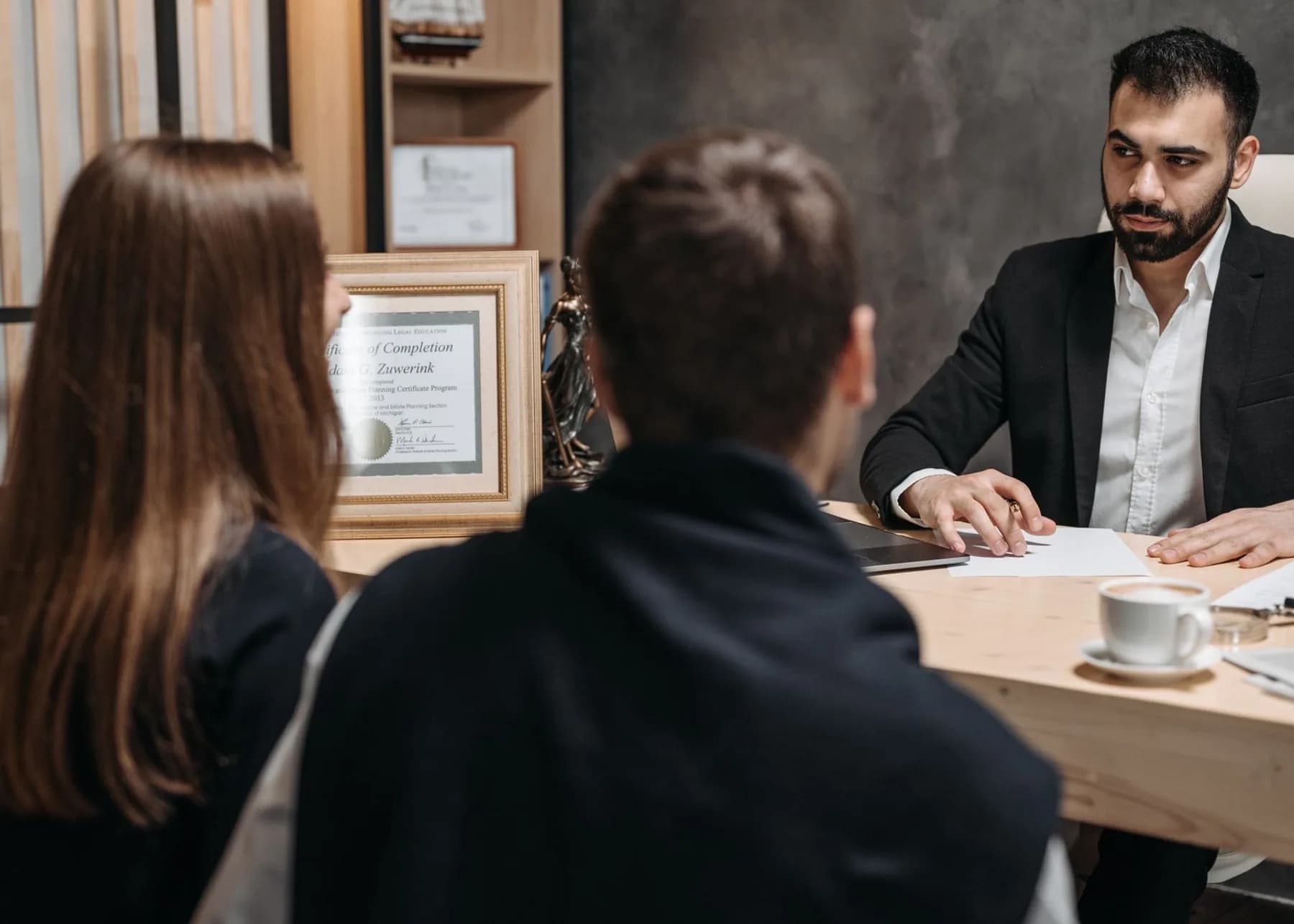 A legal adviser discussing documents with clients in a professional office